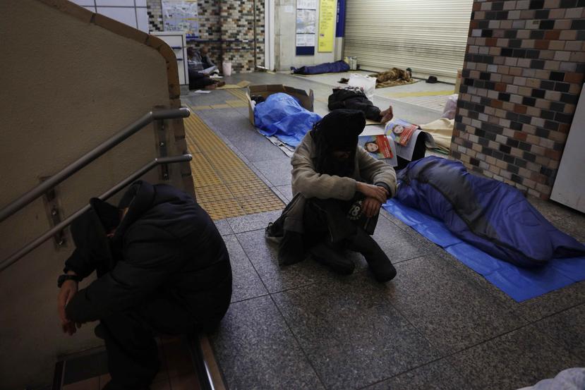 En esta fotografía de archivo del 9 de junio de 2020, personas sin casa duermen en el piso en la estación de Shinjuku, en Tokio. (AP Foto/Jae C. Hong, Archivo)
