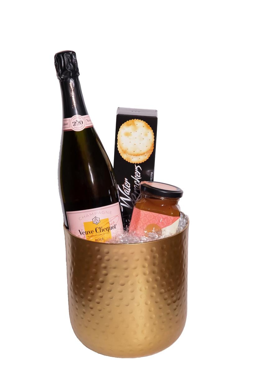 Hielera dorada con champaña Veuve Clicquot Rose y conservas.