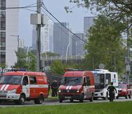 Vehículos policiales y de emergencias están estacionados al lado de los escombros de un dron caído cerca del terraplén Karamyshevskaya en Moscú, viernes 11 de agosto de 2023. (AP Foto)