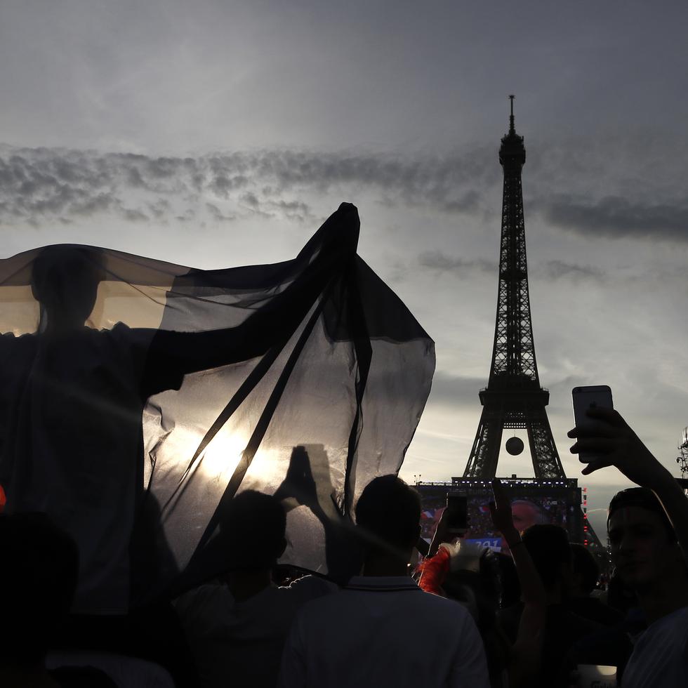 En esta imagen de archivo, un aficionado despliega una bandera de Francia en una zona habilitada para hinchas en las inmediaciones de la Torre Eiffel, durante un juego de la Eurocopa 2016 entre Portugal y Francia, el 10 de julio de 2016 en París. (AP Foto/Laurent Cipriani, archivo)