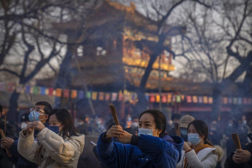 Visitantes queman incienso en el templo Lama Temple en Beijing.