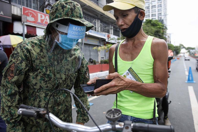 Un militar pide la documentación a un ciudadano en Manila. (Agencia EFE)