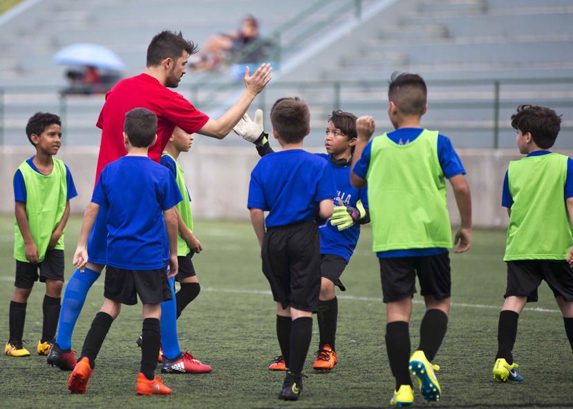El delantero español del New York City Football Club, David Villa, felicita a uno de los participantes en las clínicas de ayer de la David Villa Soccer Academy en el Bayamón Soccer Complex.
