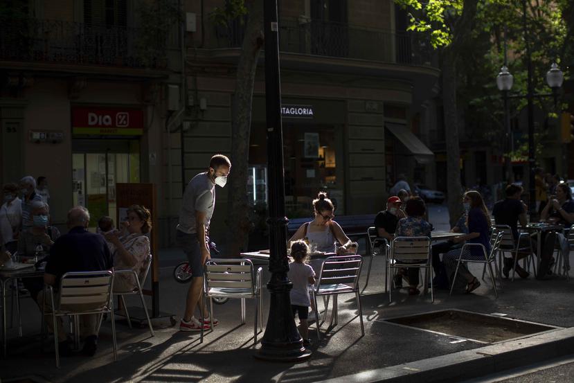 Clientes se sientan para un consumir en el área de la acera de un restaurante en Barcelona, España. (AP)