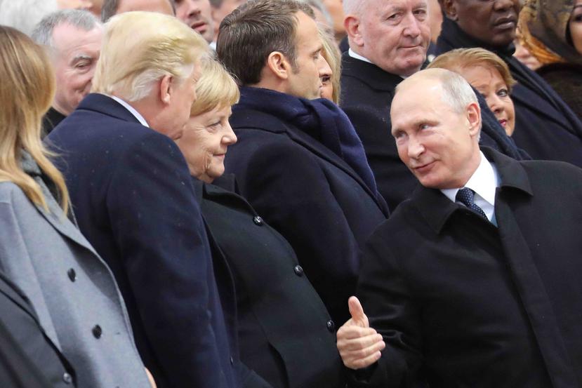 El presidente ruso, Vladimir Putin, conversa con la canciller alemana, Angela Merkel, y Donald Trump en una ceremonia en el Arco de Triunfo de París. (AP)