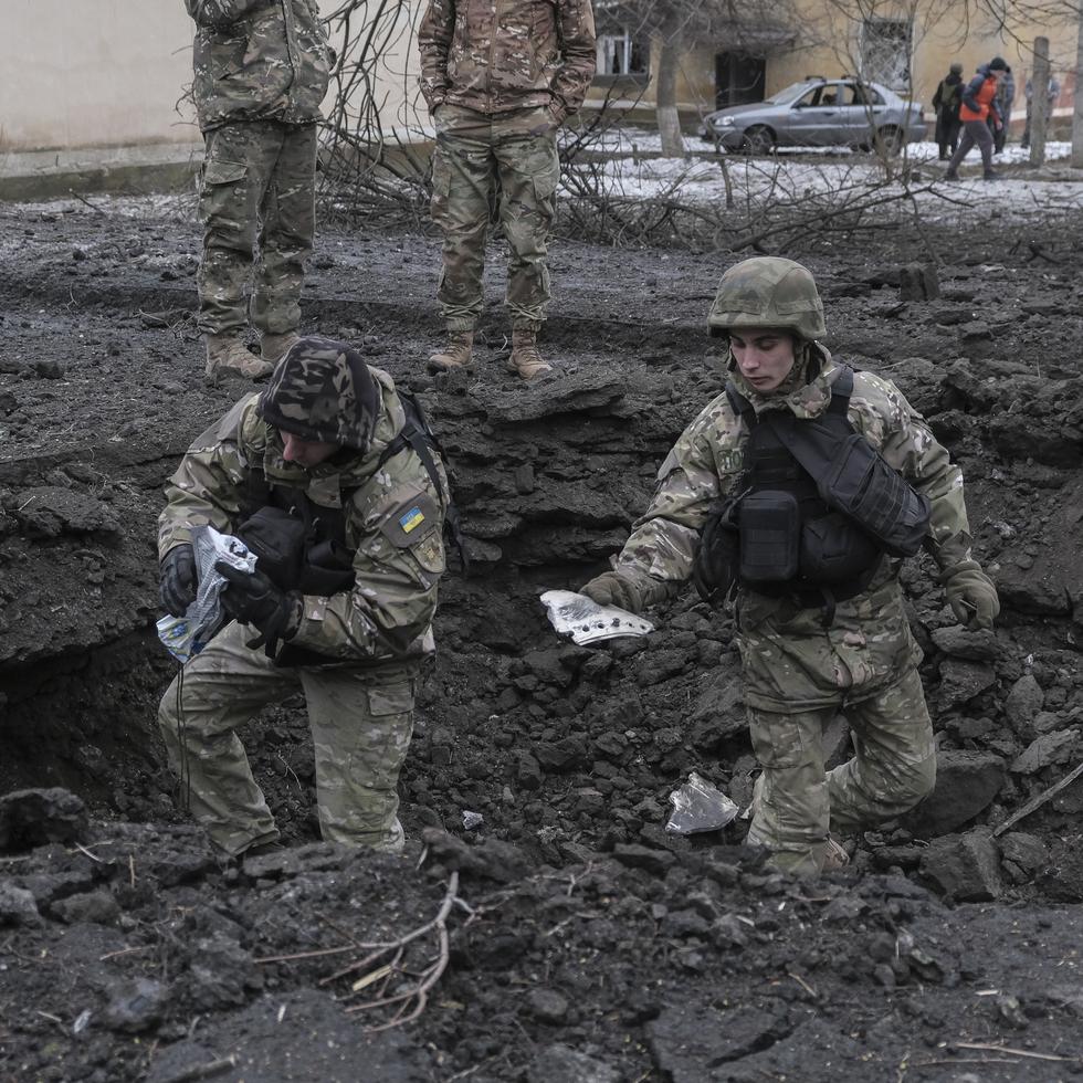 Militares ucranianos inspeccionan el cráter de un proyectil tras un ataque con cohetes contra una zona residencial en Kramatorsk, en la región de Donetsk, en el este de Ucrania, este 2 de febrero. (EFE/EPA/SERGEY SHESTAK)
