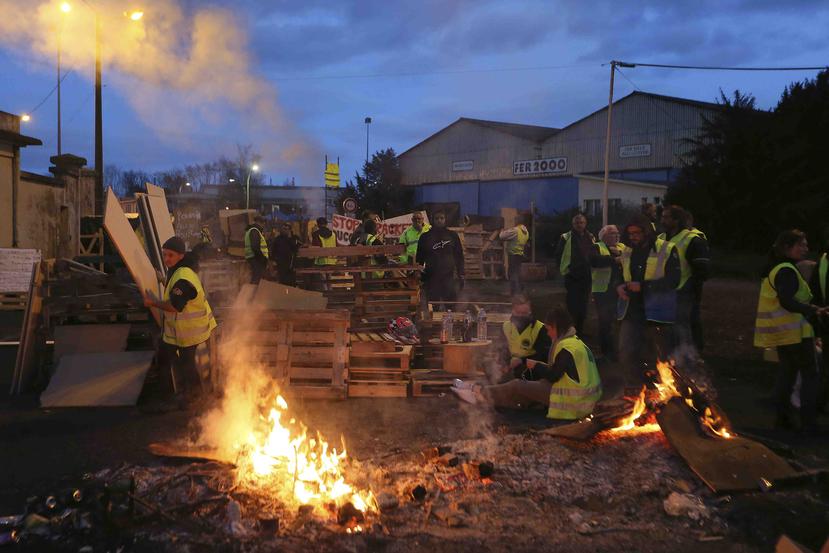 La foto de archivo del 5 de diciembre de 2018 muestra una barricada erigida por "chalecos amarillos" para impedir la entrada a un depósito de combustibles en Le Mans, Francia.  (AP /David Vincent)