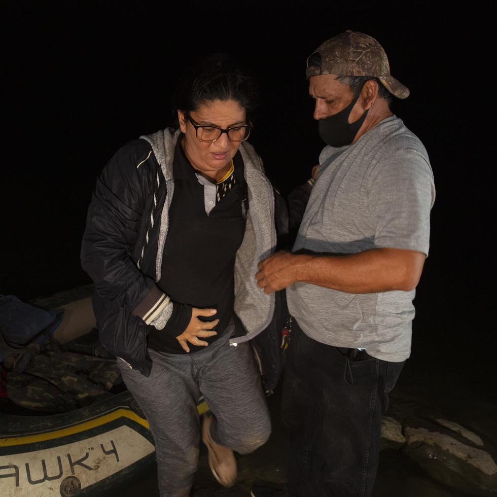Un voluntario ayuda a la inmigrante guatemalteca Mayra Culio, quien está embarazada, a bajar de una balsa inflable luego de cruzar el río Bravo, en Roma, Texas.
