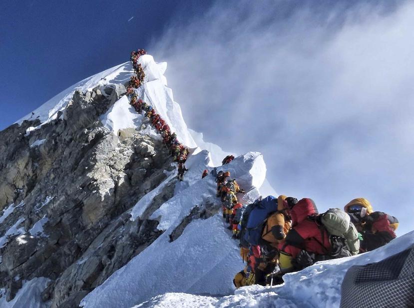 En esta imagen, tomada el 22 de mayo de 2019, una larga fila de monta eros ascendien al pico del Everest. (Nimsdai Project Possible v a AP)