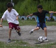 Dos niños juegan a fútbol previo a un partido de la liga “Papi libre” en la colonia Reparto Las Cañas del municipio de Ilopango.