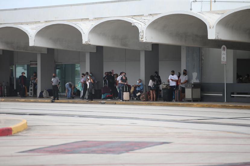 Las personas a las afueras del aeropuerto en espera de instrucciones para poder volver a entrar.