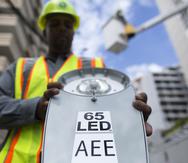 Un empleado de la Autoridad de Energia Electrica (AEE) muestra el nuevo foco led que están siendo instalados en la avenida Ashford de Conado hoy 9 de Septiembre, 2018 en San Juan, Puerto Rico. SUMINISTRADA/ Alvin Baez