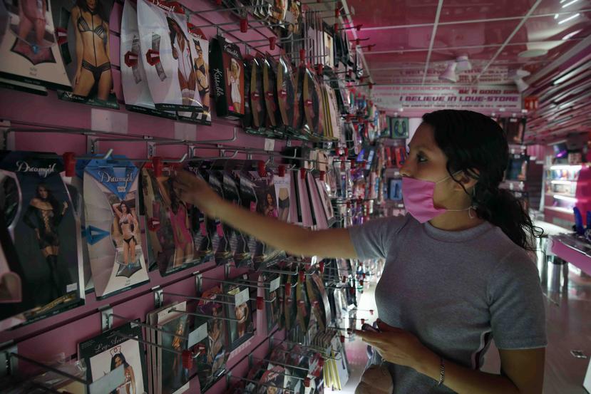 Una empleada de la tienda Erotika en México organiza la mercancía utilizando una mascarilla. (AP)