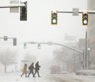 La gente cruza la 300 sur en Main Street durante una tormenta de nieve en Salt Lake City, Utah.