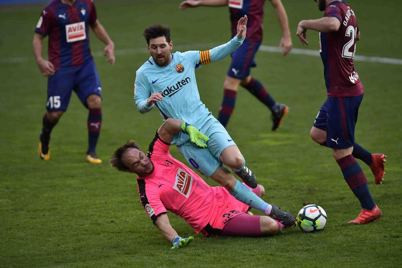 El portero del  Eibar Marco Dmitrovic choca con Lionel Messi, del Barcelona. (AP)
