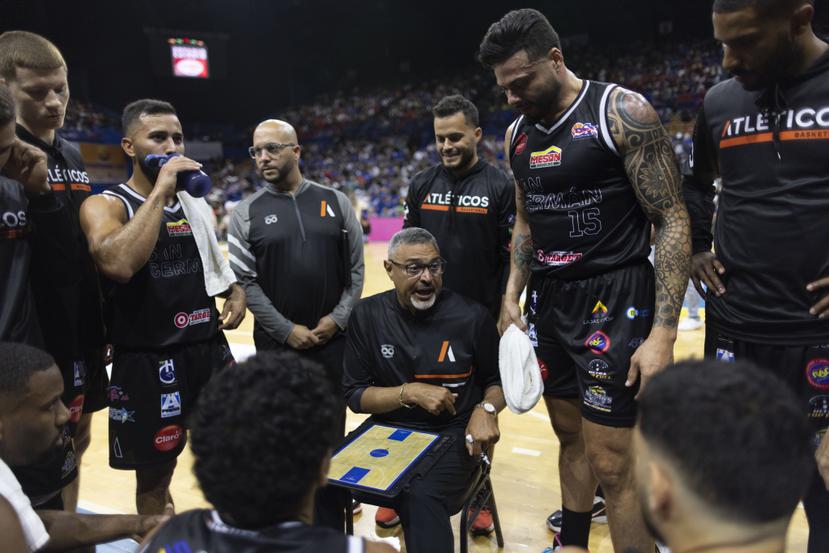 El dirigente Eddie Casiano le imparte instrucciones a los jugadores de los Atléticos de San Germán durante el partido inaugural del Baloncesto Superior Nacional en Bayamón.