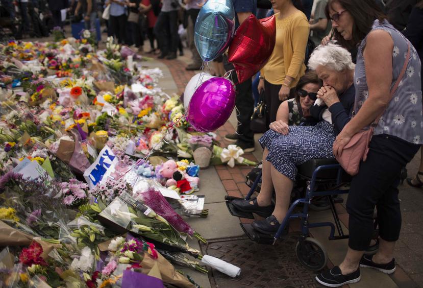 Una mujer llora tras dejar flores en el lugar donde un atacante suicida mató a más de 20 personas que acudieron a un concierto de la cantante Ariana Grande. (AP)