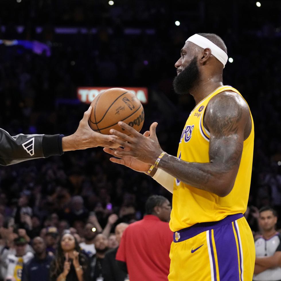 Kareem Abdul-Jabbar hace entrega de un balón conmemorativo a LeBron James, quien se convirtió en el máximo anotador en la historia de la NBA.
