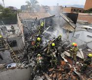 Bomberos trabajan en el lugar del accidente de una avioneta que cayó sobre casas en una zona residencial de Medellín, Colombia.