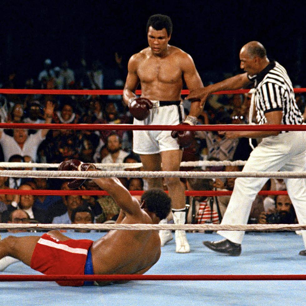 El árbitro Zack Clayton (derecha) interviene después de que Muhammad Ali derribara al campeón defensor de peso pesado George Foreman en el octavo asalto de su pelea por el campeonato el 30 de octubre de 1974, en Kinshasa, Zaire.