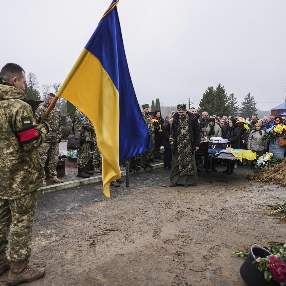 Soldados ucranianos asisten al entierro de su compañero Georgiy Plisak, asesinado por las fuerzas rusas, en un cementerio cerca de Lutsk, en Ucrania, el 31 de marzo de 2022. (AP Foto/Evgeniy Maloletka)