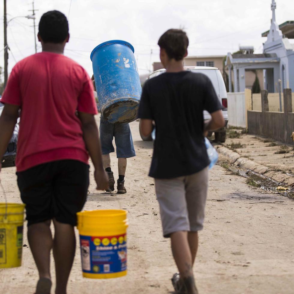 Vecinos de Toaville, en busca de agua tras el paso del huracán María.