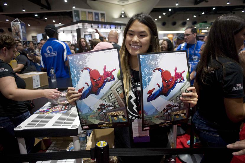 Una mujer muestra dos carteles de Spiderman durante la apertura oficial de la Convención Internacional de Cómics de San Diego. (EFE)