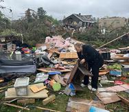 Theresa Haske clasifica los escombros que quedaron en su garaje después de que un tornado arrasara el viernes 20 de mayo de 2022 la comunidad de Gaylord, en el estado de Michigan.