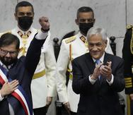 El nuevo presidente de Chile, Gabriel Boric, a la izquierda, levanta el puño mientras el mandatario saliente, Sebastián Piñera, aplaude durante la ceremonia de juramentación de Boric en el Congreso en Valparaíso, Chile, el viernes 11 de marzo de 2022.