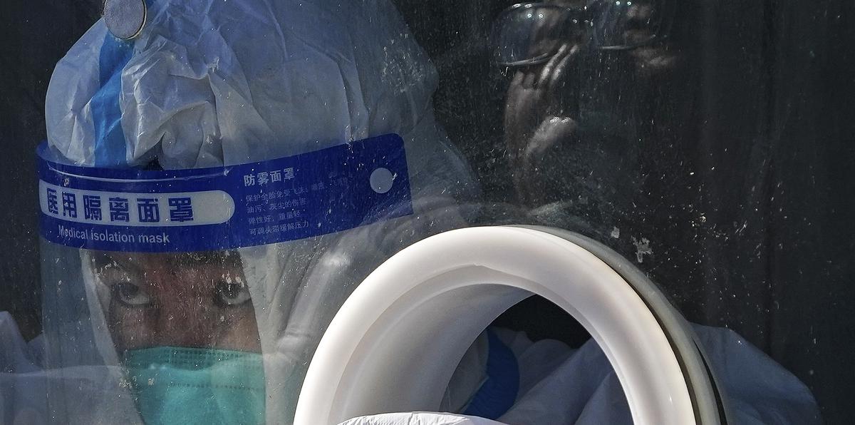 Un trabajador médico con equipo de protección recoge una muestra de un residente en un centro de pruebas de coronavirus en el distrito de Xichen en Beijing.