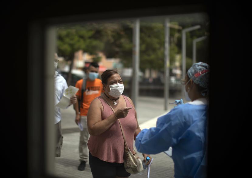 Una trabajadora de salud recibe pacientes a las afueras del hospital Hospitalet en Barcelona donde intentan contener el virus.
