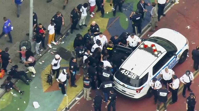 In this image taken from video provided by WABC-TV, internet influencer Kai Cenat, center, is helped into a New York Police vehicle near Union Square, Friday, Aug. 4, 2023, in New York. Police in New York City struggled to control a crowd of thousands of people who gathered in Manhattan's Union Square for the Internet personality's video game console giveaway that got out of hand. (WABC-TV via AP)
