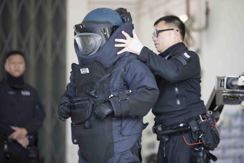 Un agente especializado en desactivación de explosivos se protege durante una exhibición para la prensa, en Hong Kong, el 6 de diciembre de 2019. (AP/Vincent Thian)