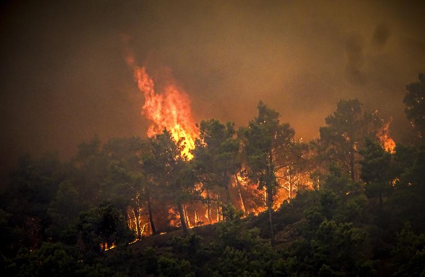 Las llamas se alzan de un incendio forestla en la islad de Rodas, Grecia, el sábado 22 de julio de 2023. (Argyris Mantikos/Eurokinissi via AP)