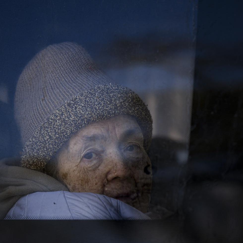 Una refugiada que huye de la guerra de la vecina Ucrania mira por la ventana de un autobús tras cruzar la frontera con Rumania, el lunes 14 de marzo de 2022, en Siret, Rumania. (AP Foto/Andreea Alexandru)