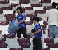 Hinchas de Japón limpian las gradas al final del juego del Grupo E entre Alemania y Japón, en el estadio Jalifa Internacional, en Doha, Catar, el 23 de noviembre de 2022.