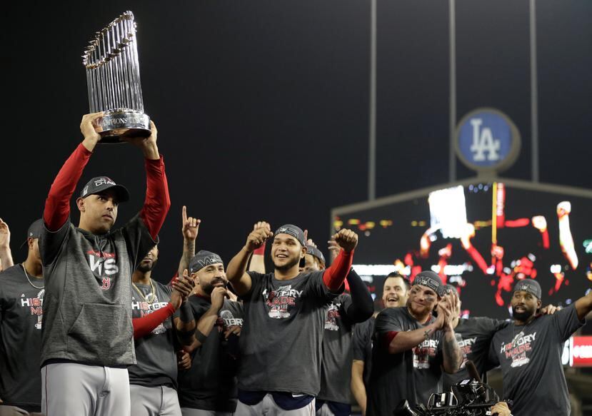 Alex Cora levanta el trofeo de la Serie Mundial luego que sus Medias Rojas derrotaran en cinco partidos a los Dodgers en el clásico de Otoño. (AP)
