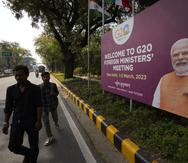 Residentes pasan una pancarta con la fotografía de Narendra Modi, el primer ministro indio, dando la bienvenida a los delegados de la reunión de ministros de Relaciones Exteriores del G20, en Nueva Delhi, India, el miércoles, 1 de marzo de 2023. (Foto AP/Manish Swarup)