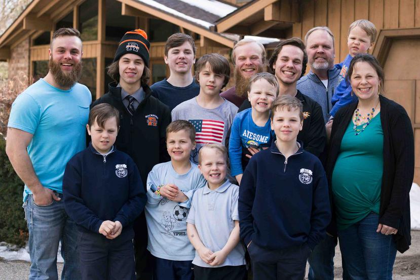Los Schwandt y sus 13 hijos posan para un retrato frente a su casa en Grand Rapids, Michigan. (AP)