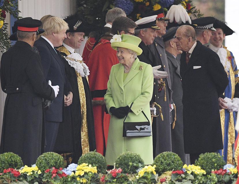 La reina Elizabeth II de Inglaterra  y el duque Felipe de Edimburgo saludan al primer ministro británico (a la izquierda)  Boris Johnson, en un acto en Londres. EFE/FACUNDO ARRIZABALAGA/Archivo