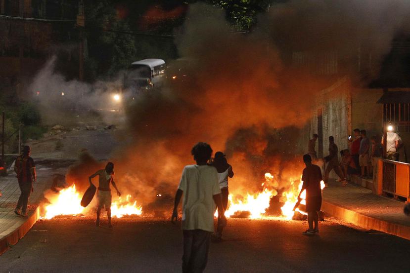 Manifestantes incendian neumáticos para impedir el tráfico en una calle durante una protesta para exigir la renuncia del presidente Juan Orlando Hernández, en Tegucigalpa, Honduras. (AP/Elmer Martínez)