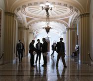 Congressional staffers wait in the ornate corridor outside the Senate chamber during a delay in work on the Democrats' $1.9 trillion COVID-19 relief bill, at the Capitol in Washington, Friday, March 5, 2021. (AP Photo/J. Scott Applewhite)