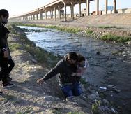 Fotografía del 5 de marzo de 2021 donde se observa a una familia que intenta cruzar el Río Bravo hacia Estado Unidos, por la frontera de Ciudad Juárez, Chihuahua (México).