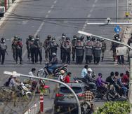 Agentes de policía forman una fila para bloquear una calle principal en Mandalay, Myanmar.