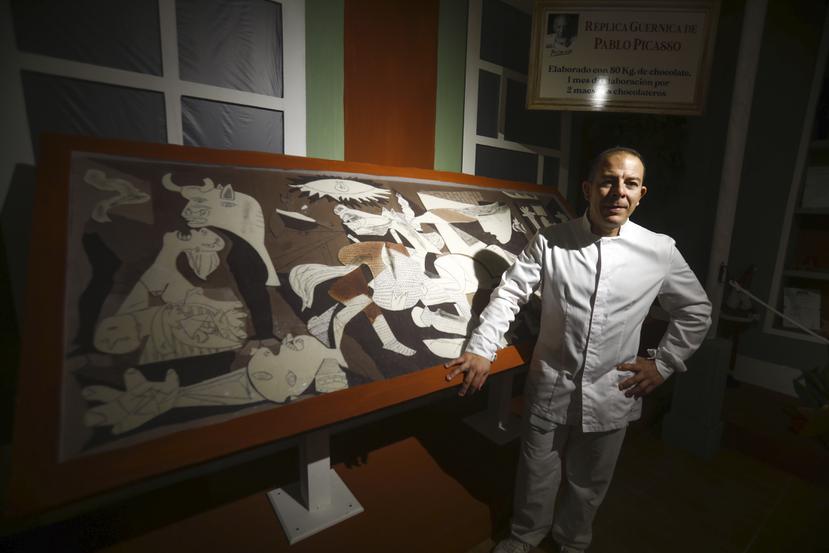 Jorge Garrido ante el cuadro del Guernica elaborado con chocolate en el obrador Galleros Artesanos de Rute (Córdoba, España).