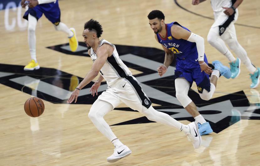 El escolta de los Spurs de San Antonio Derrick White deja atrás al base de los Nuggets de Denver Jamal Murray en la primera mitad del tercer juego de la serie de playoffs de primera ronda. (AP)