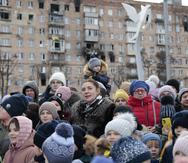 Ciudadanos locales observan una actuación cerca de un árbol de Navidad decorado para las festividades de Navidad ortodoxa y Año Nuevo en Mariupol, en la región de Donetsk controlada por Rusia, en el este de Ucrania.