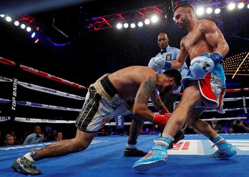 El boricua Christopher ‘Pitufo’ Díaz, derriba a Bryant Cruz durante el tercer round de su combate. (AP)