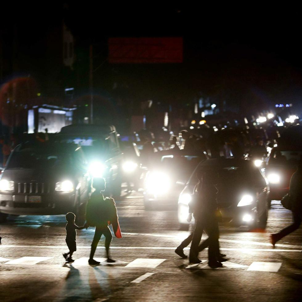 Residentes cruzan una calle en la oscuridad tras un apagón en Caracas, Venezuela. (AP Foto/Eduardo Verdugo)