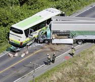 Investigadores revisan el lugar donde se registró un choque entre un autobús y un camión en Yakumo, en la prefectura de Hokkaido, en el norte de Japón, el lunes 18 de junio de 2023. (Kyodo News vía AP)